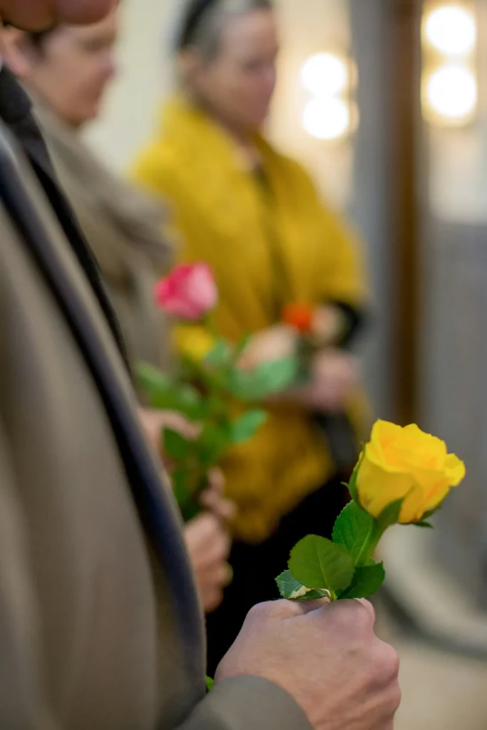 Main tenant une rose jaune lors d'une cérémonie de funérailles.
